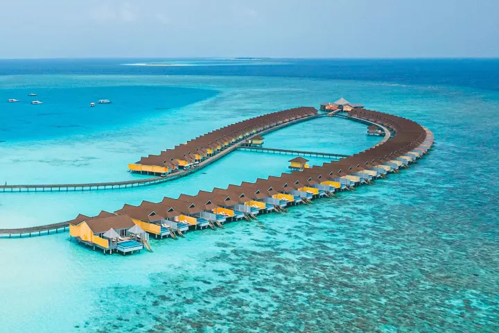 The Standard, Huruvalhi Maldives — панорамный вид с дрона на зелёный остров, домашний риф и лагуну