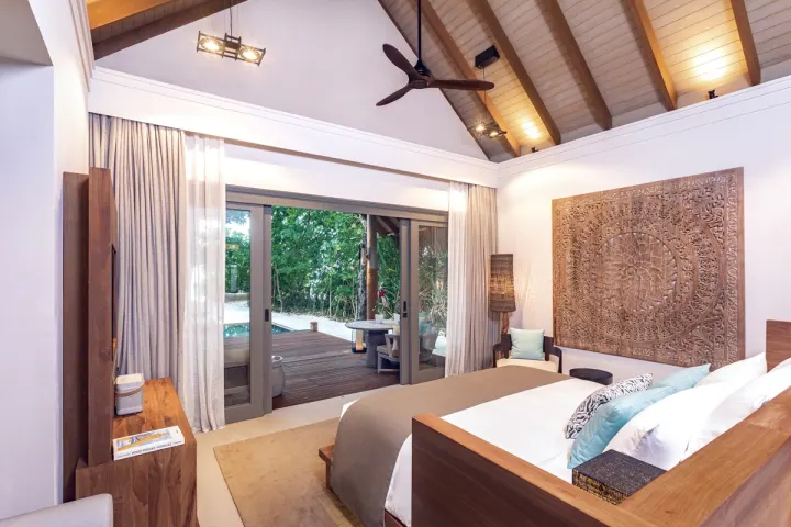 Vakkaru Maldives, Мальдивы — интерьер виллы Vakkaru Maldives — просторная спальня с выходом на террасу и к океану
