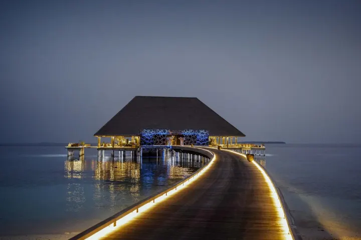 Velaa Private Island — вечерний ресторан над водой с подсветкой