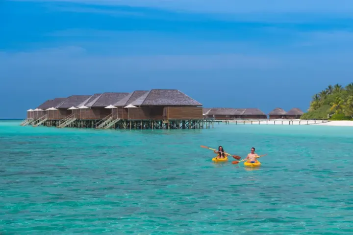Veligandu Island Resort & Spa — пара плавает на каяке в прозрачной воде лагуны