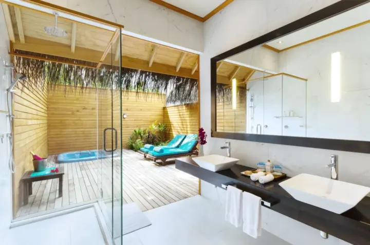 Veligandu Island Resort & Spa — светлая ванная комната с душем и выходом на террасу