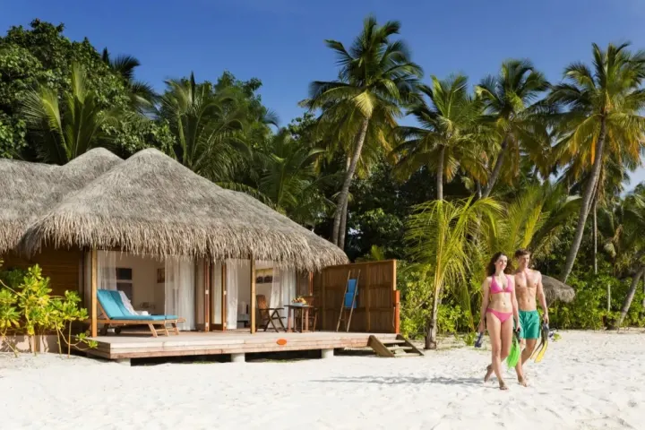 Veligandu Island Resort & Spa — пляжная вилла с деревянной террасой и шезлонгами