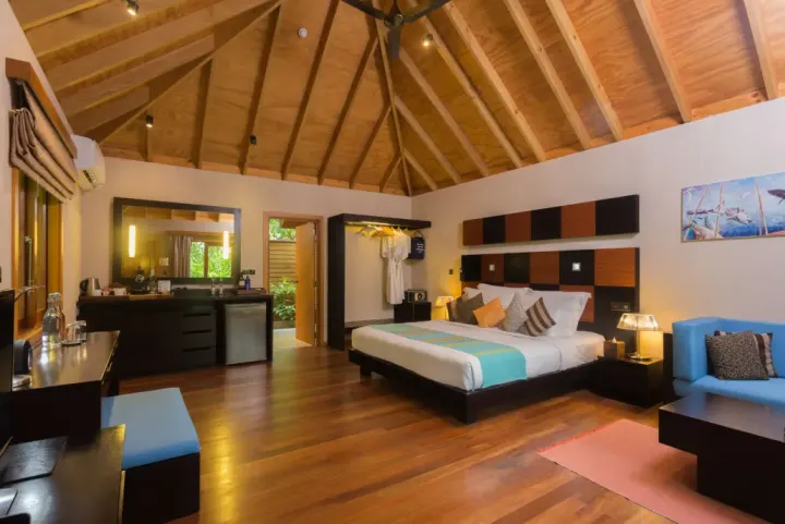 Veligandu Island Resort & Spa — просторная спальня с кроватью и деревянным потолком