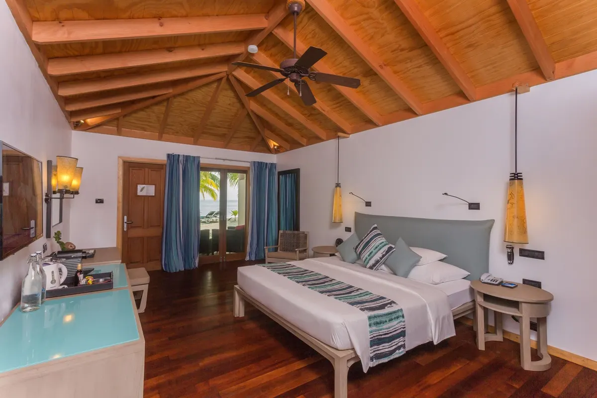 Vilamendhoo Island Resort & Spa — спальня с кроватью с балдахином и диваном