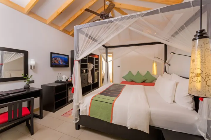 Vilamendhoo Island Resort & Spa, Мальдивы — интерьер виллы Vilamendhoo Island Resort & Spa — просторная спальня со светлой деревянной мебелью