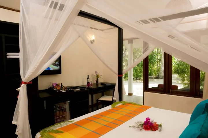 Vilamendhoo Island Resort & Spa, Мальдивы — интерьер виллы Vilamendhoo Island Resort & Spa — уютный интерьер комнаты с зоной отдыха