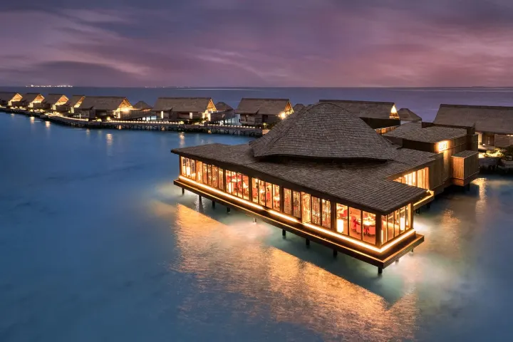 Waldorf Astoria Maldives Ithaafushi, Мальдивы — ресторан Waldorf Astoria Maldives Ithaafushi — ресторан над водой в вечернее время