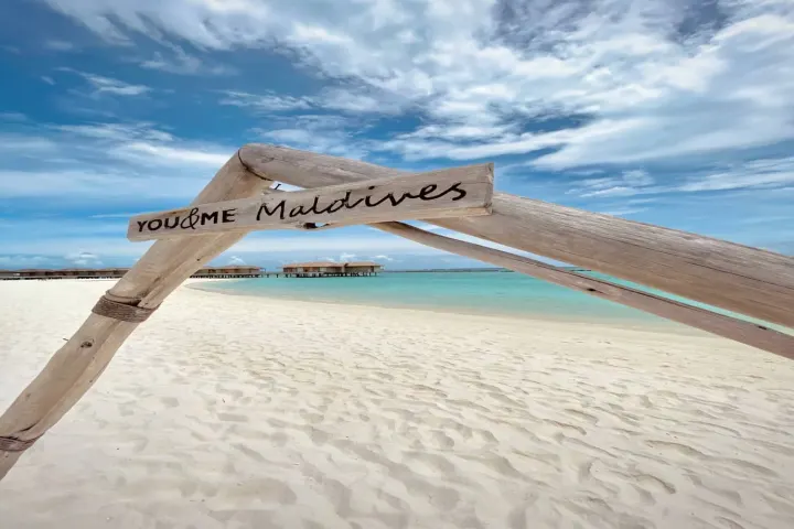 You & Me by Cocoon Maldives — деревянная рамка с названием отеля на белоснежном пляже